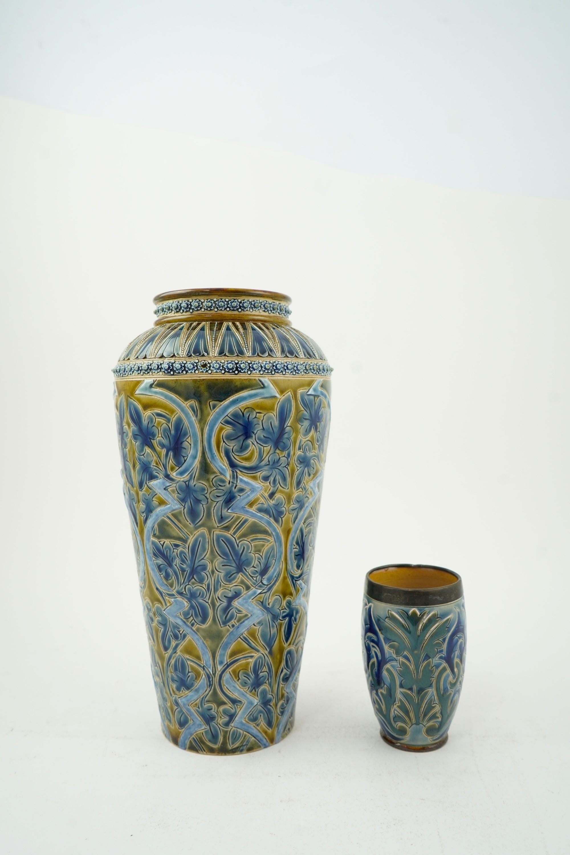 A Doulton Edith Lupton stoneware vase, drill hole to base, together with a similar Martha Rogers silver mounted cup, Tallest 31cm